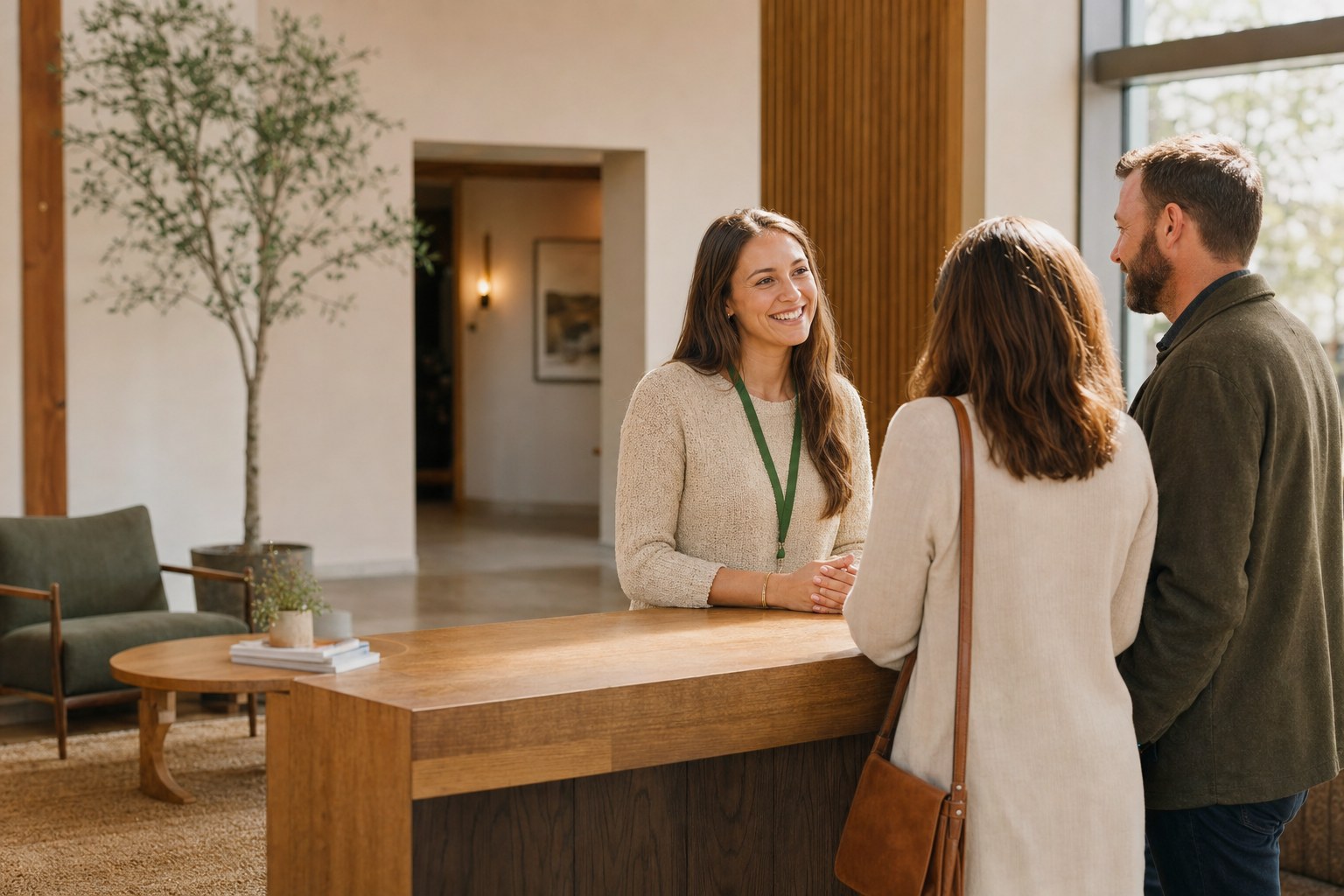 A volunteer welcoming a couple at a church lobby desk